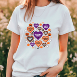 Person wearing a white t-shirt with Halloween-themed graphics in a field.