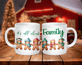 Two white mugs with Christmas-themed designs on a wooden surface.