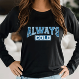 Person wearing a black sweatshirt with 'ALWAYS COLD' text in blue and white.