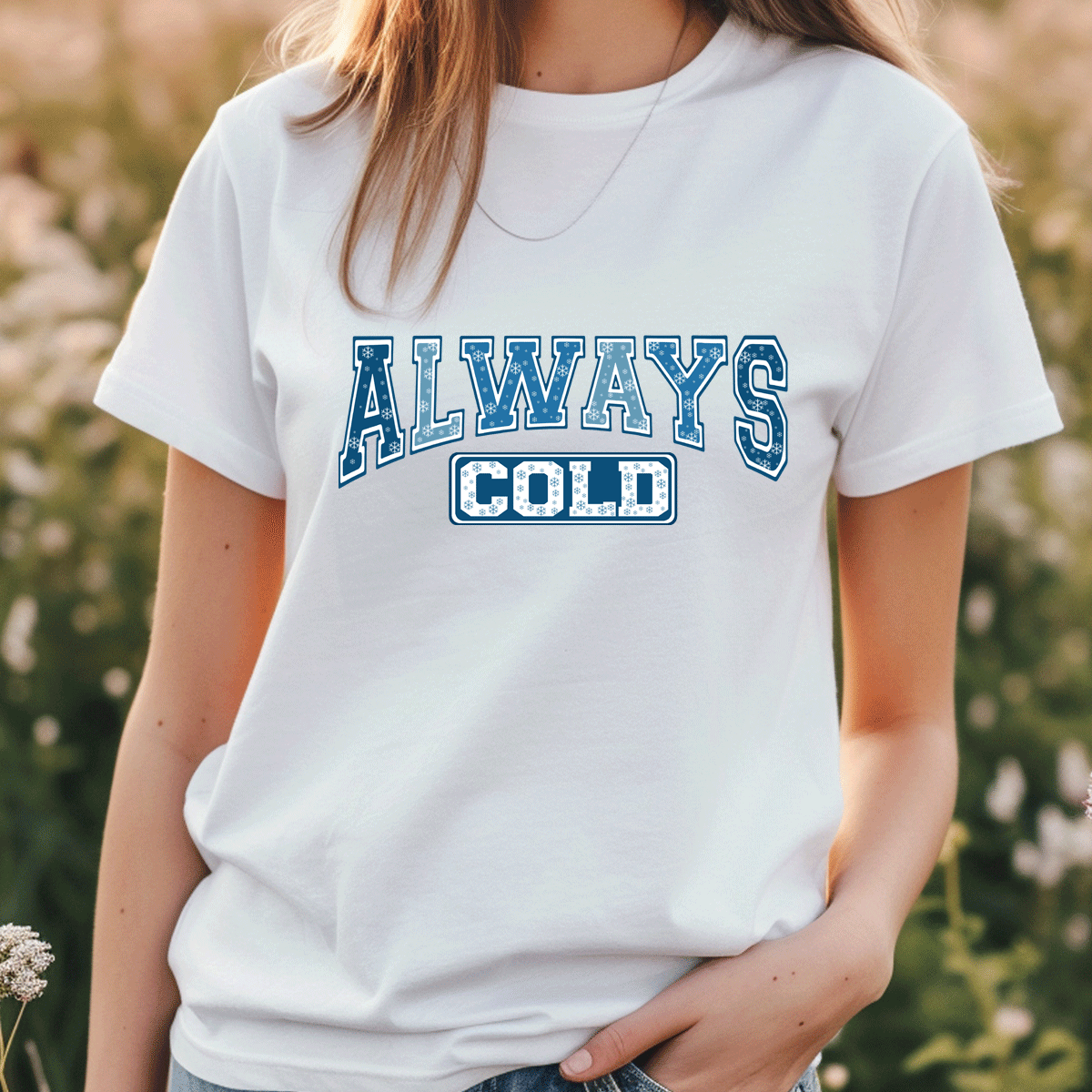 Person wearing a white t-shirt with 'ALWAYS COLD' text in blue outdoors.