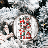 Decorative Christmas ornament with reindeer, snowman, and stockings on a wooden background, hanging on a tree.