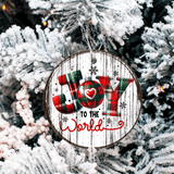 Christmas ornament with 'Joy to the World' text on a wooden background, hanging on a decorated tree.