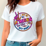White t-shirt with colorful graphic design and text worn by a person.