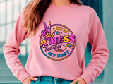 Person wearing a pink sweatshirt with colorful graphic design and text.