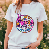 Person wearing a white t-shirt with colorful graphic design outdoors