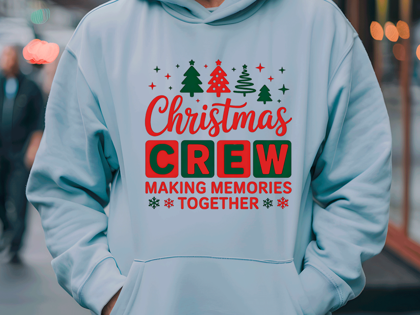 Light blue hoodie with Christmas-themed text and graphics worn by a person in an urban setting.