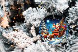 Decorative Christmas ornament with Santa Claus in a sleigh surrounded by reindeer on a snowy night scene, hanging on a decorated tree.