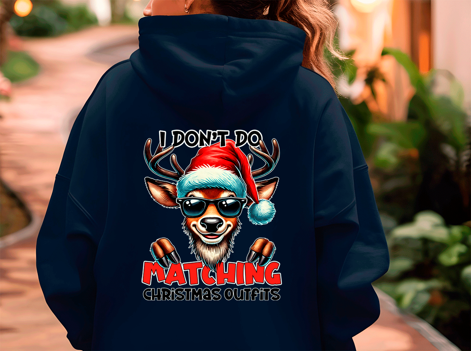 Person wearing a navy hoodie with a reindeer graphic and text on the back.