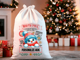 White Santa sack with festive design and text, Christmas tree and gifts in the background