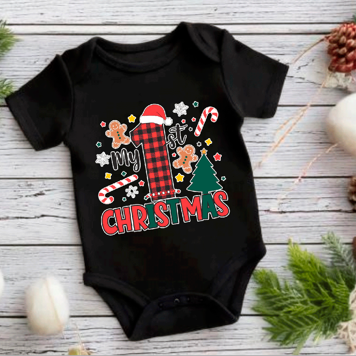 Black baby onesie with Christmas-themed design on a wooden surface.