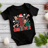 Black baby onesie with Christmas-themed design on a wooden surface.