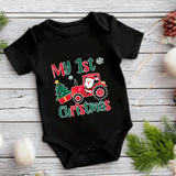 Black baby onesie with Christmas-themed design on a wooden surface.