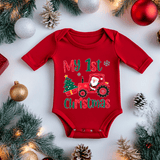 Red baby onesie with 'My 1st Christmas' text and Santa on a tractor design, surrounded by Christmas decorations.