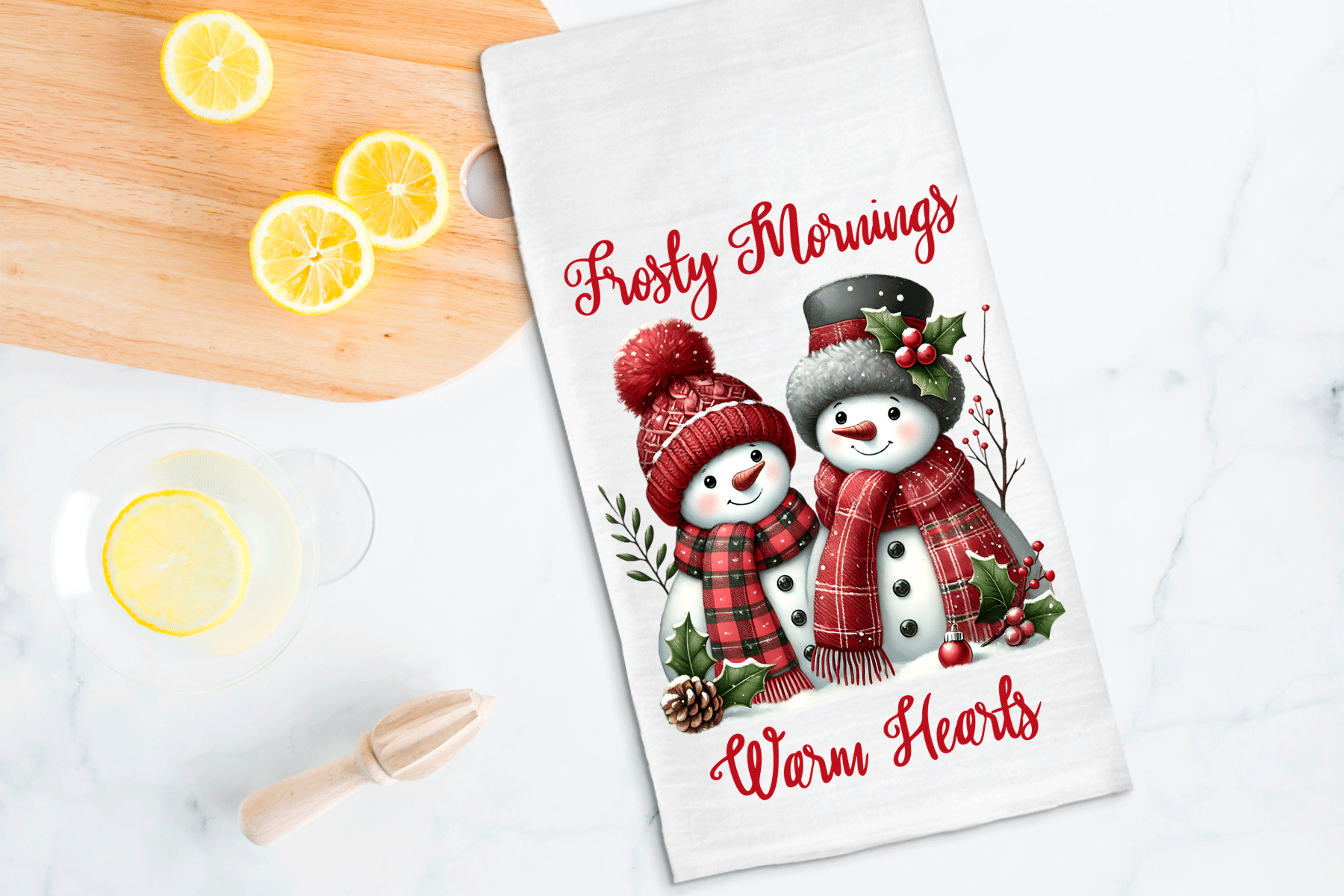 Tea towel with snowman design and text on a kitchen counter with lemons.