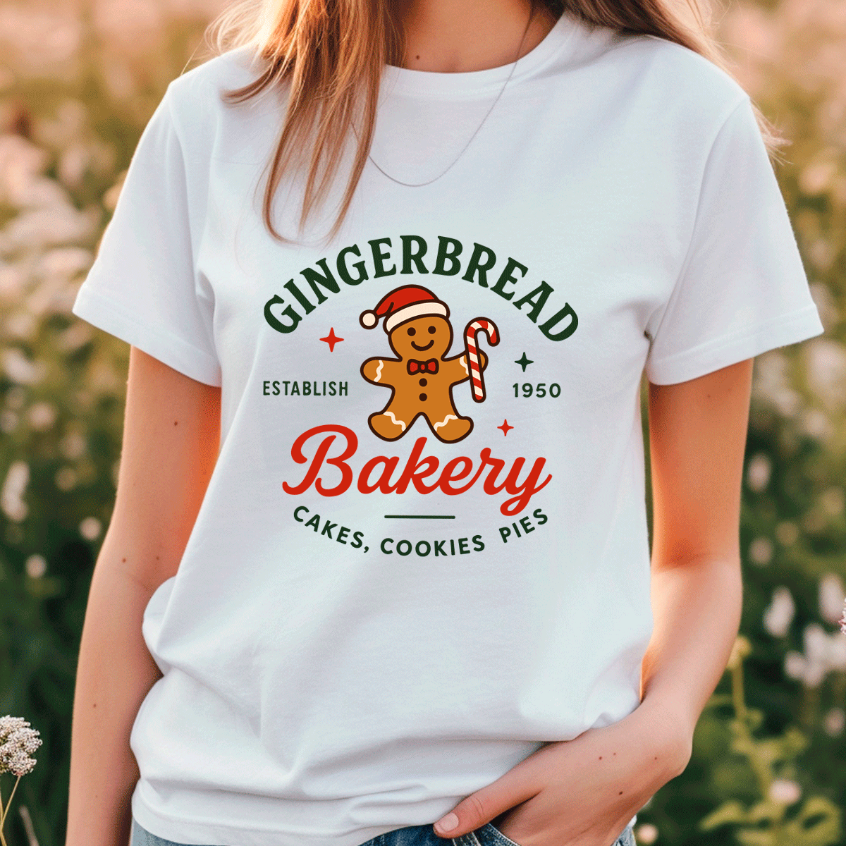 Person wearing a white t-shirt with a gingerbread-themed bakery design.