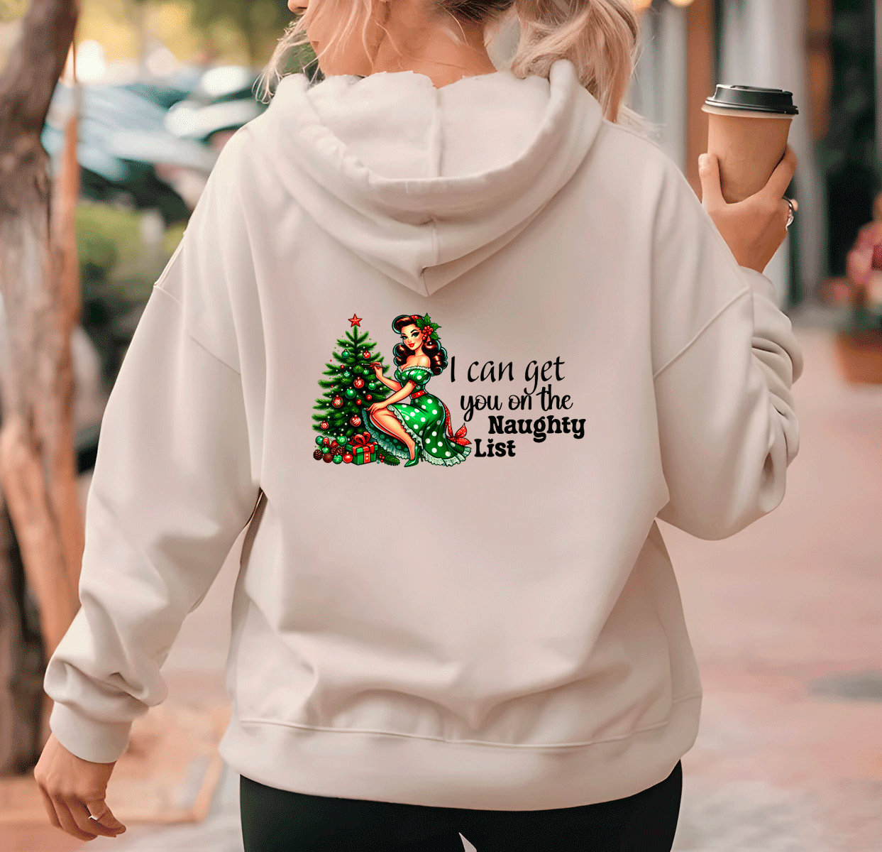 Person wearing a hoodie with a Christmas-themed design and text.