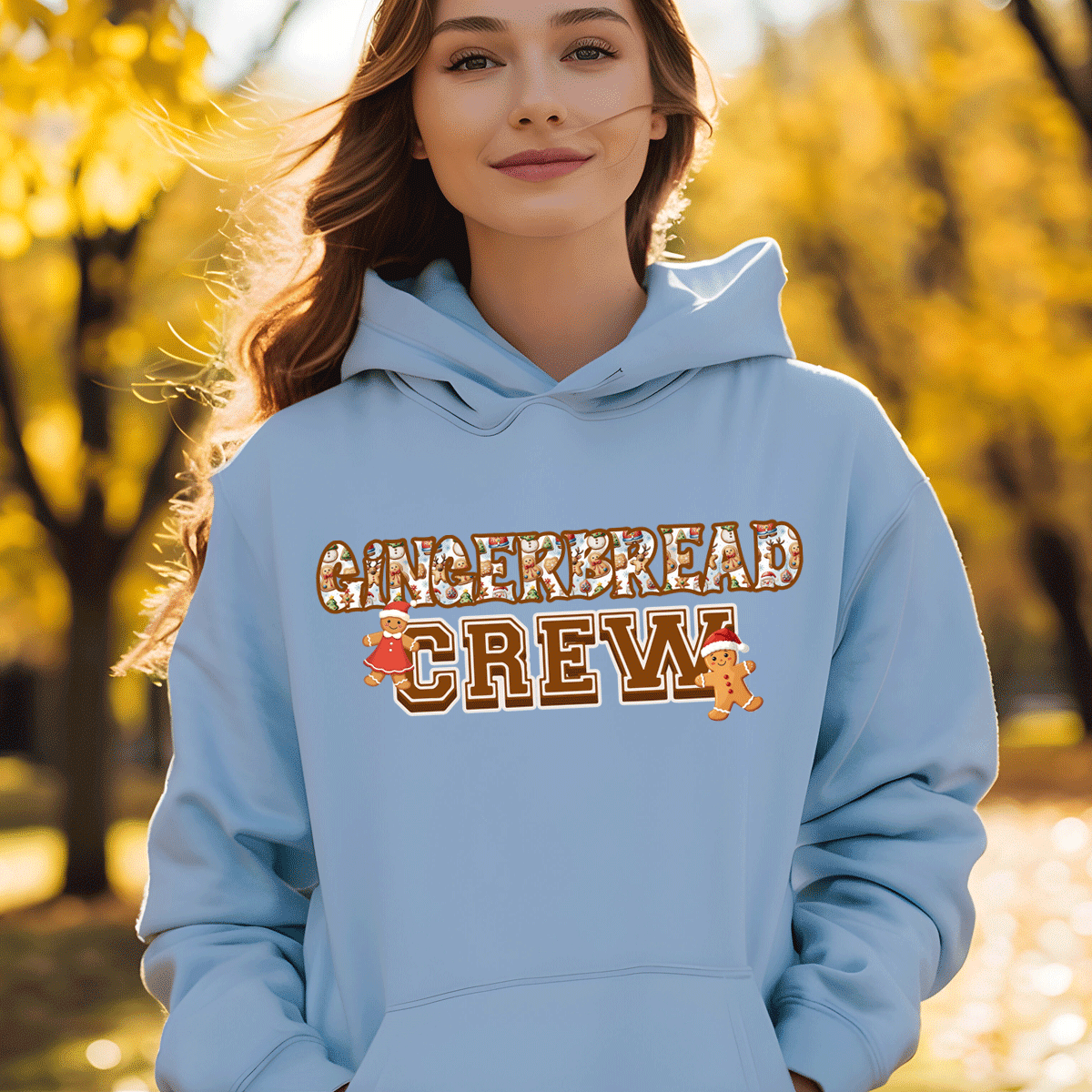 Person wearing a light blue hoodie with 'Gingerbread Crew' text in an autumn setting