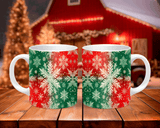 Two Christmas-themed mugs with red and green patterns on a wooden table.