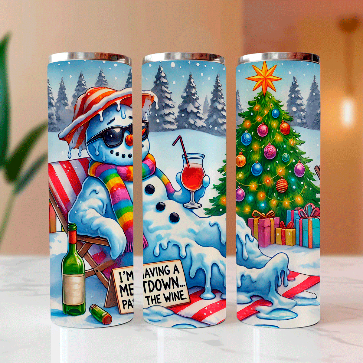 Three tumblers with a snowman design and Christmas tree, placed on a surface.