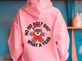 Pink hoodie with a graphic design and text on the back, against a blue wall.