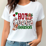 White t-shirt with 'Hot Cocoa Season' graphic design worn by a person.