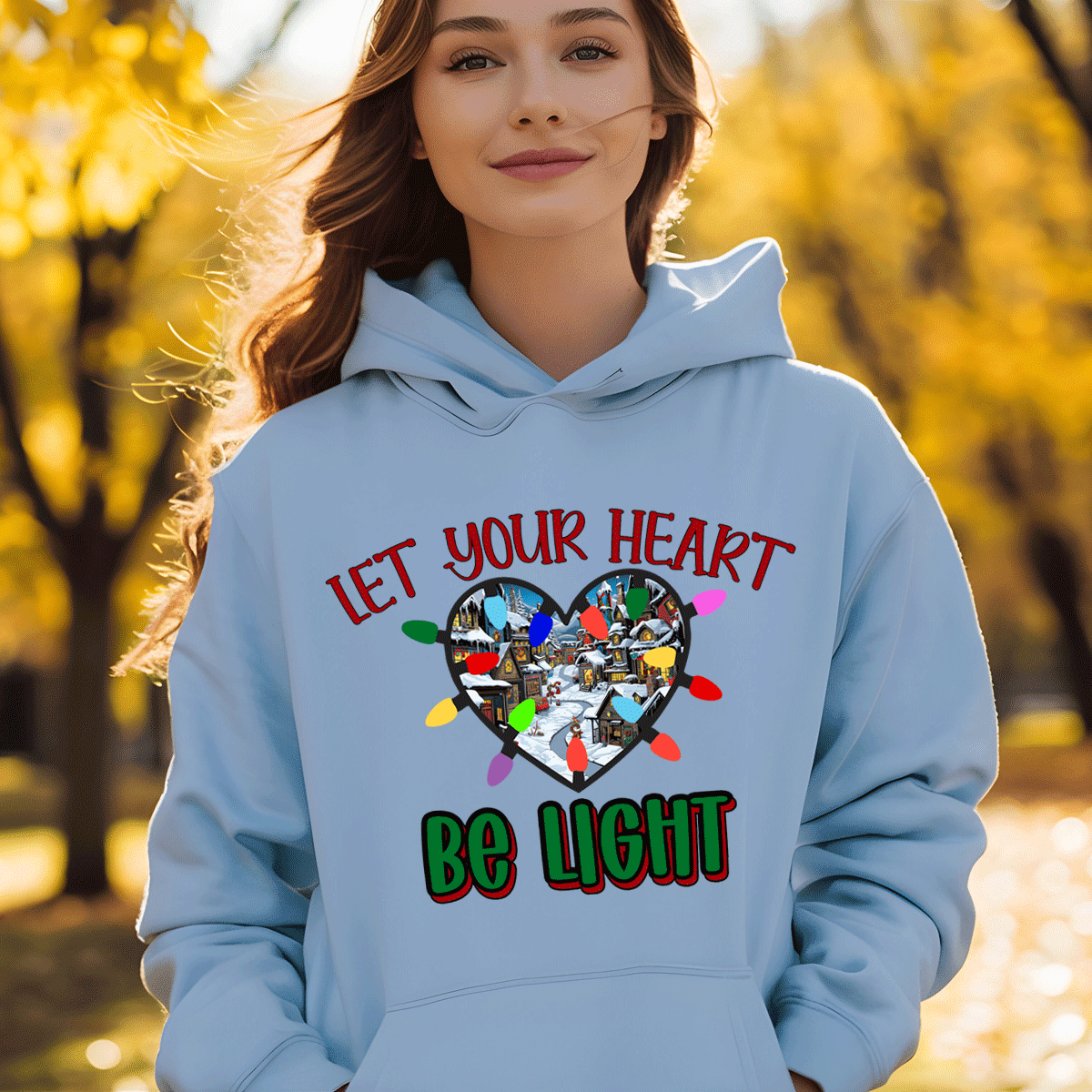 Person wearing a light blue hoodie with a heart design and text in an outdoor setting.