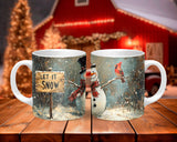 Two mugs with winter-themed designs featuring a snowman, cardinal, and 'Let It Snow' sign on a wooden surface.