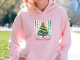 Person wearing a pink hoodie with a Christmas tree design and 'Merry & Bright' text.