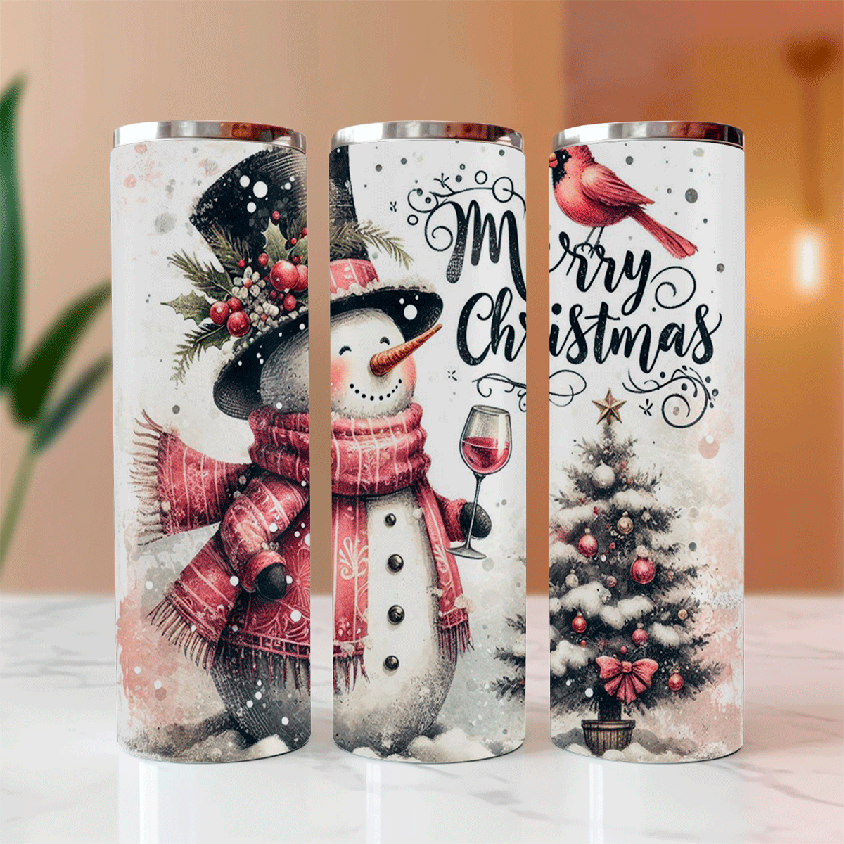 Three Christmas-themed tumblers with snowmen, trees, and 'Merry Christmas' text on a white surface.