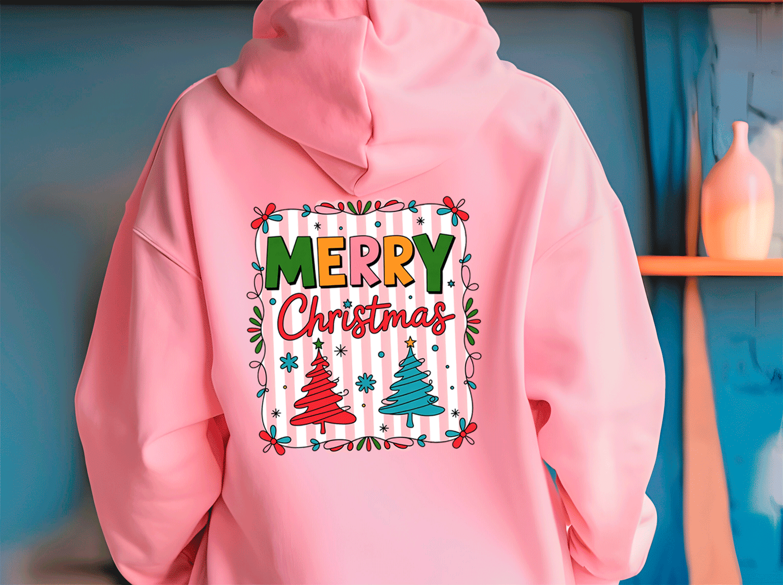 Pink hoodie with 'Merry Christmas' design on a blue wall background