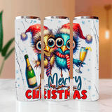 Three Christmas-themed tumblers with colorful owls and festive elements on a marble surface.