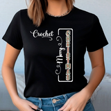 Person wearing a black t-shirt with decorative text design on a plain background