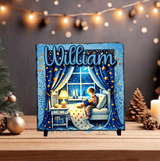 Decorative plaque with a child reading by a window, surrounded by Christmas decorations.