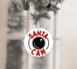 Round ornament with 'Santa Cam' text hanging on a Christmas tree.