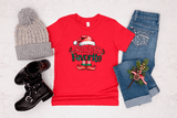 Red t-shirt with 'Santa's Favorite' design, gray beanie, black boots, and jeans on a light background