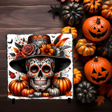 Decorative skull with colorful top hat and flowers surrounded by pumpkins on a wooden background