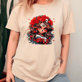 Beige t-shirt with a colorful graphic design of a face with flowers and skulls on a plain background