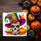 Colorful sugar skull design with a witch hat on a wooden background with pumpkins and leaves.