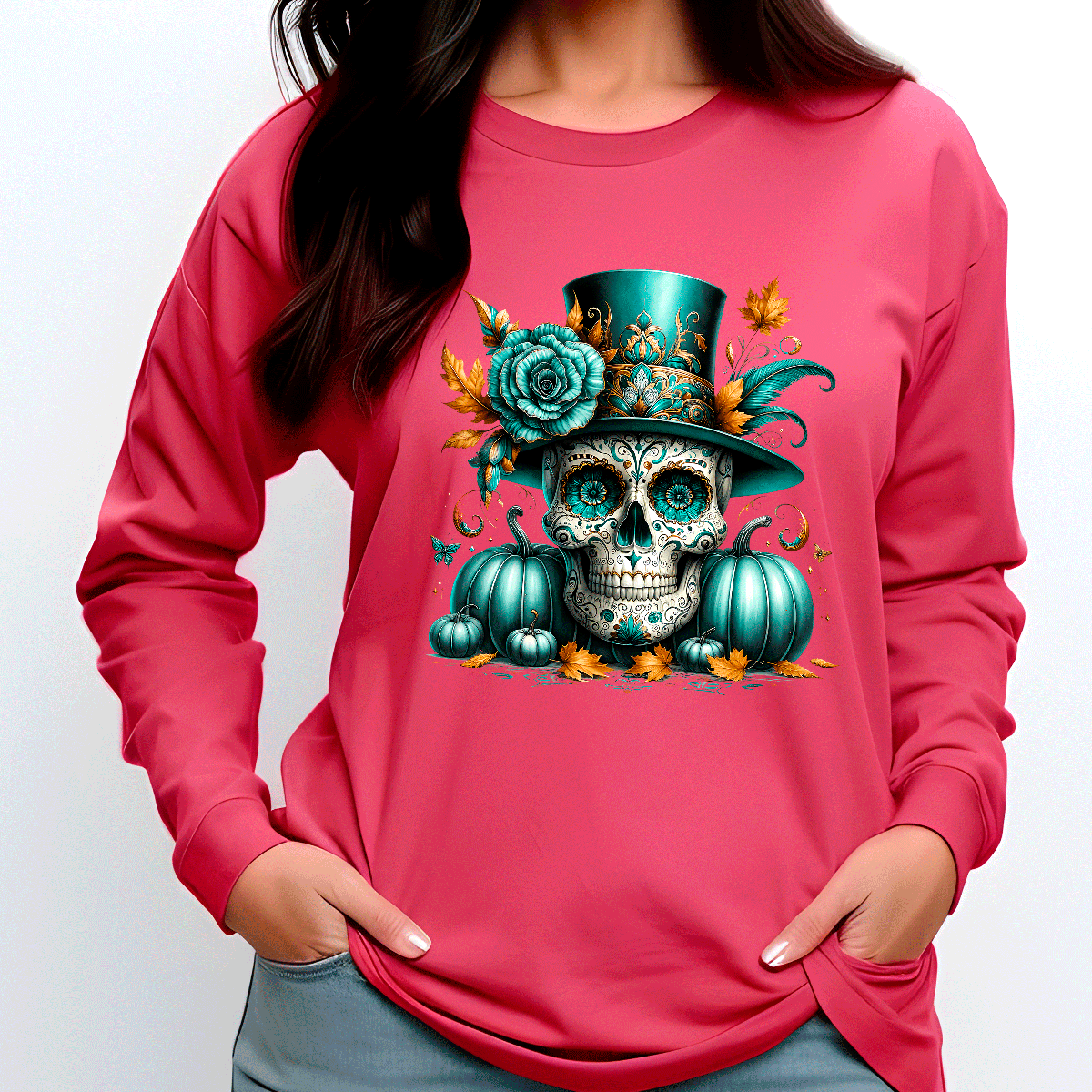 Person wearing a pink sweatshirt with a colorful skull and pumpkin design.