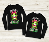 Black long-sleeve shirts with Grinch design and text on a wooden surface