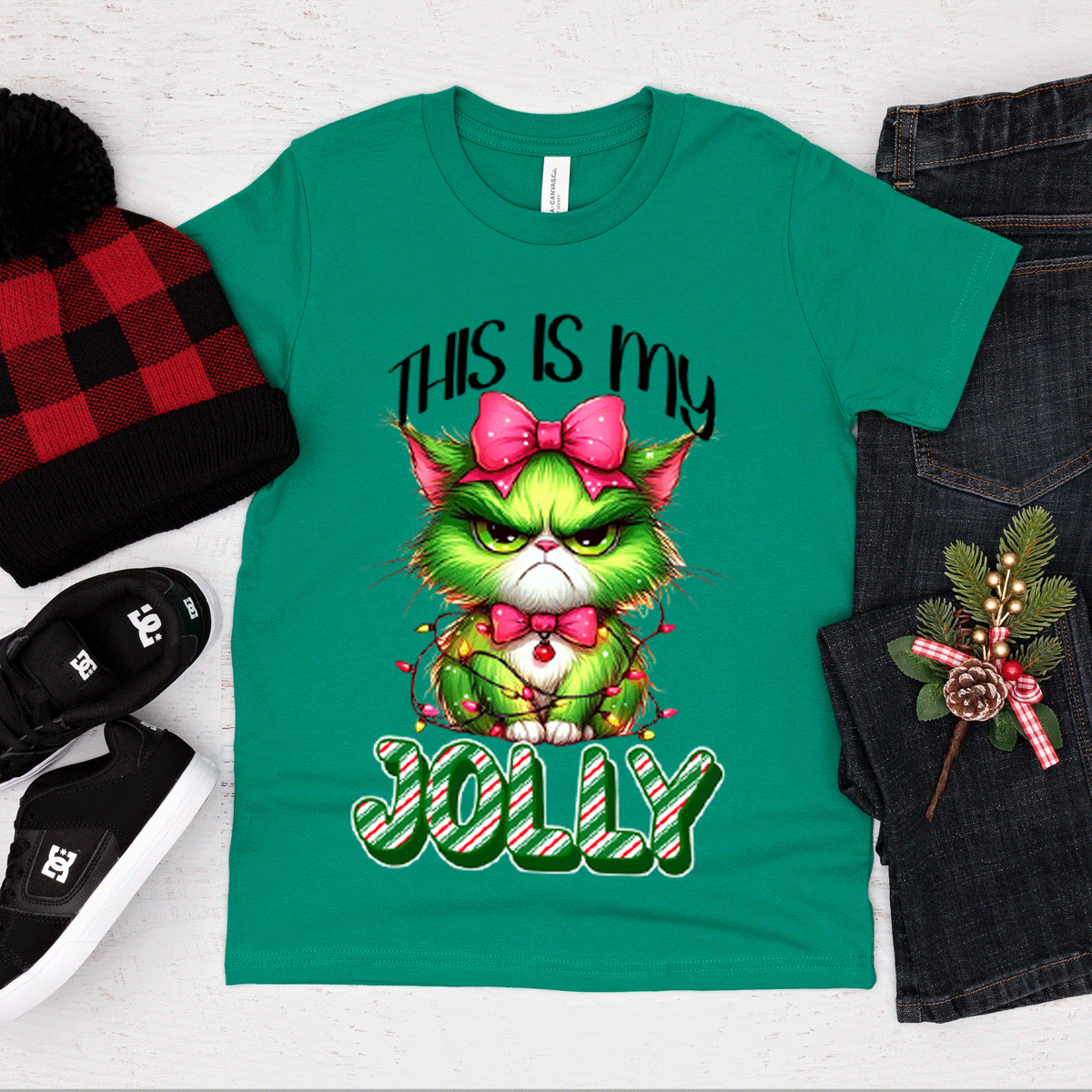 Green t-shirt with Christmas-themed design featuring a cat, surrounded by festive items on a white background.