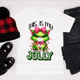 White t-shirt with Grinch graphic and 'This is my Jolly' text, surrounded by holiday-themed items on a white background.