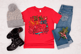Red t-shirt with festive design, gray beanie, black boots, and jeans on a light background